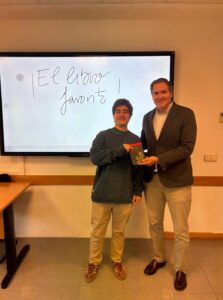 José Ignacio González, estudiante de periodismo y ganador del sorteo, recibe el libro Remedios para la vida, de la mano de Álvaro Lucas, profesor de Sociología de la comunicación